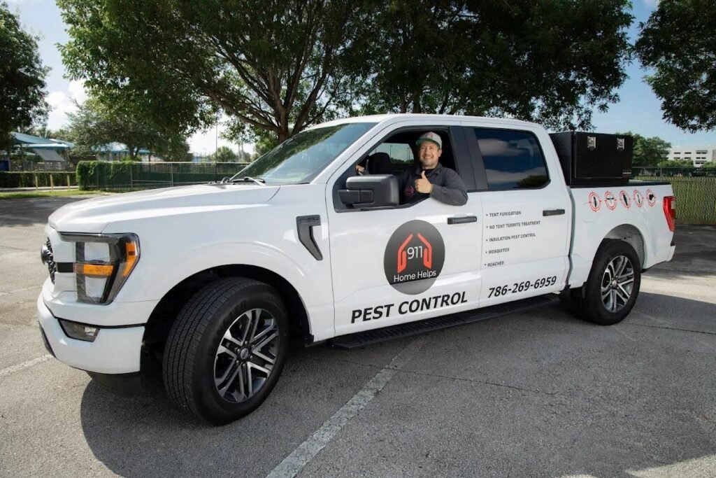 911 Home Helps pest control company vehicle with a technician smiling in the driver's seat.