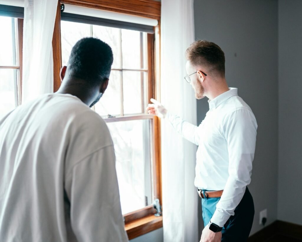 Two men are inspecting a window