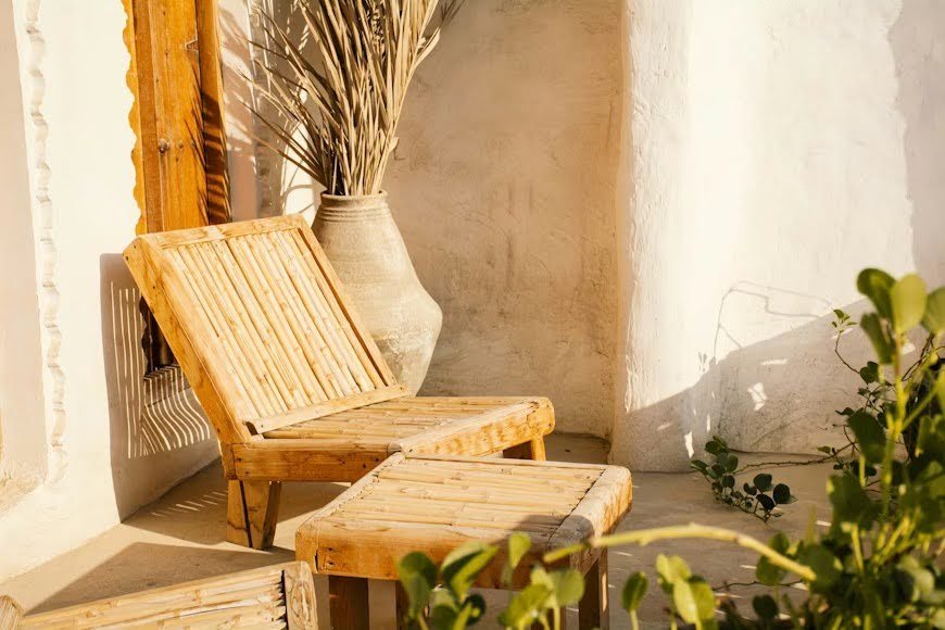 Two rustic wooden chairs placed under the sun.